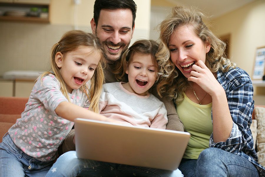 Blog - Excited Family Sitting At Home Using Laptop Together