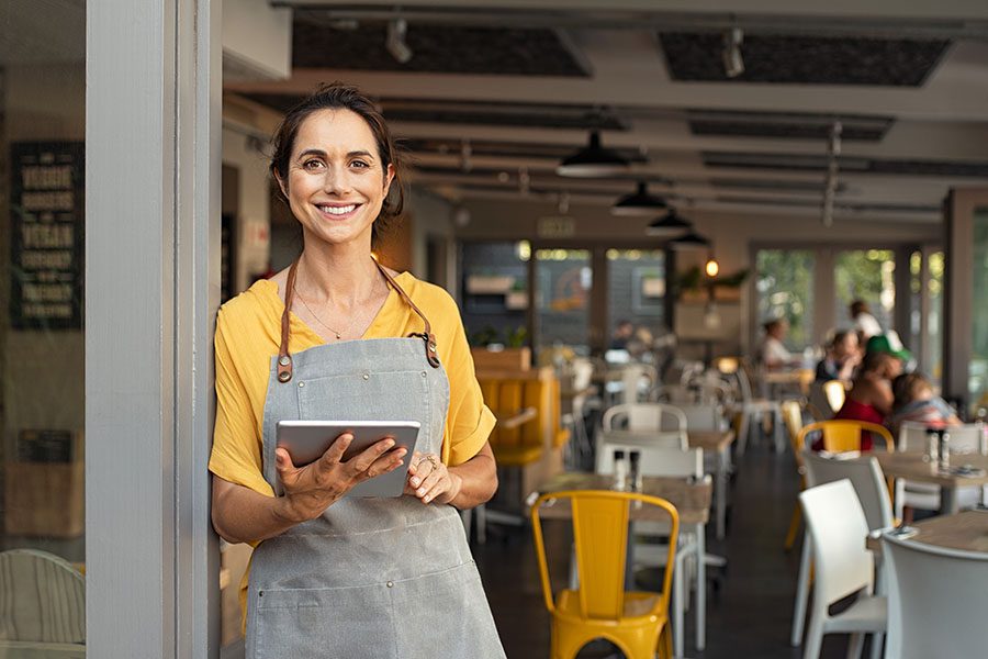 Business Insurance - Smiling Portrait Of Business Owner Standing Outside Restaurant